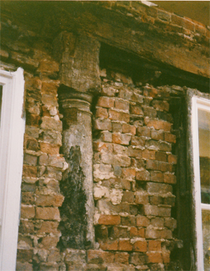 wooden pillar embedded in bricks
